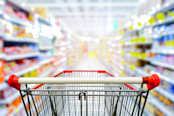 Supermarket aisle with empty red shopping cart