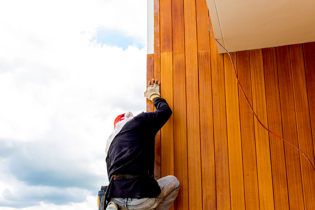 Men build siding Fiber Cement Board on wall exterior