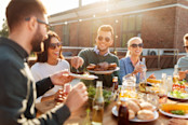 friends eating dinner at rooftop restaurant