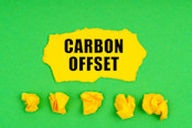 crumpled yellow paper and a sheet with the inscription -Carbon offset