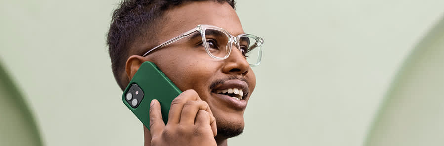En ung man pratar i sin mobiltelefon.