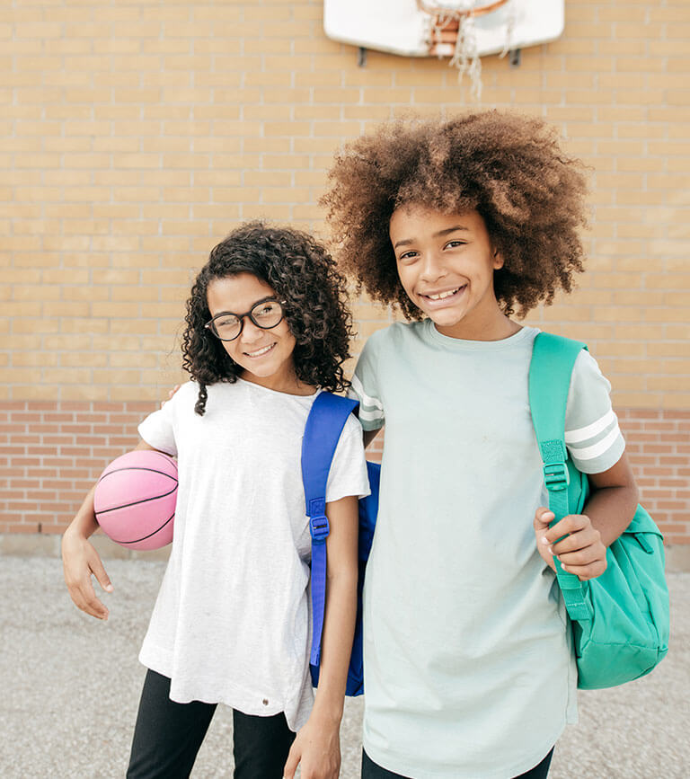 two girls near basketball hoop two girls near basketball hoop