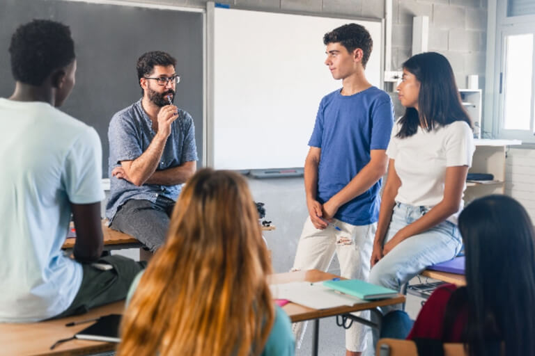 A teacher talking to students in class.
