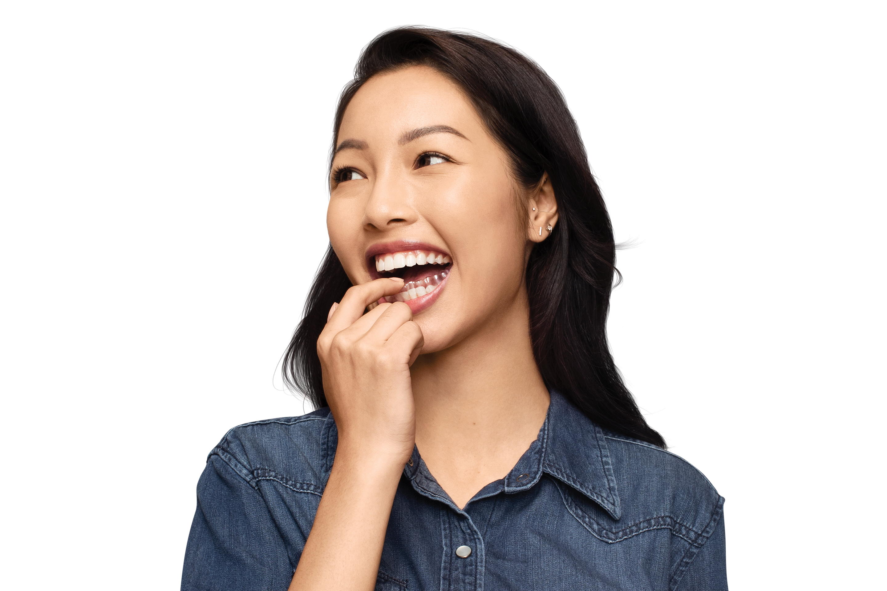 woman-in-denim-shirt-placing-aligner-on-bottom-teeth