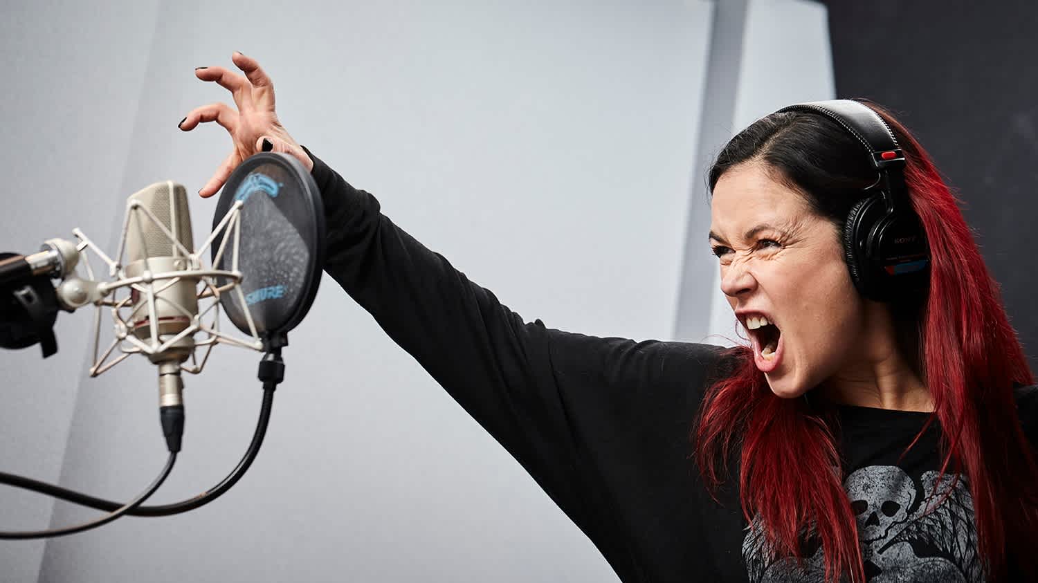 Actress doing a scene in an audio booth. She is screaming the scene.