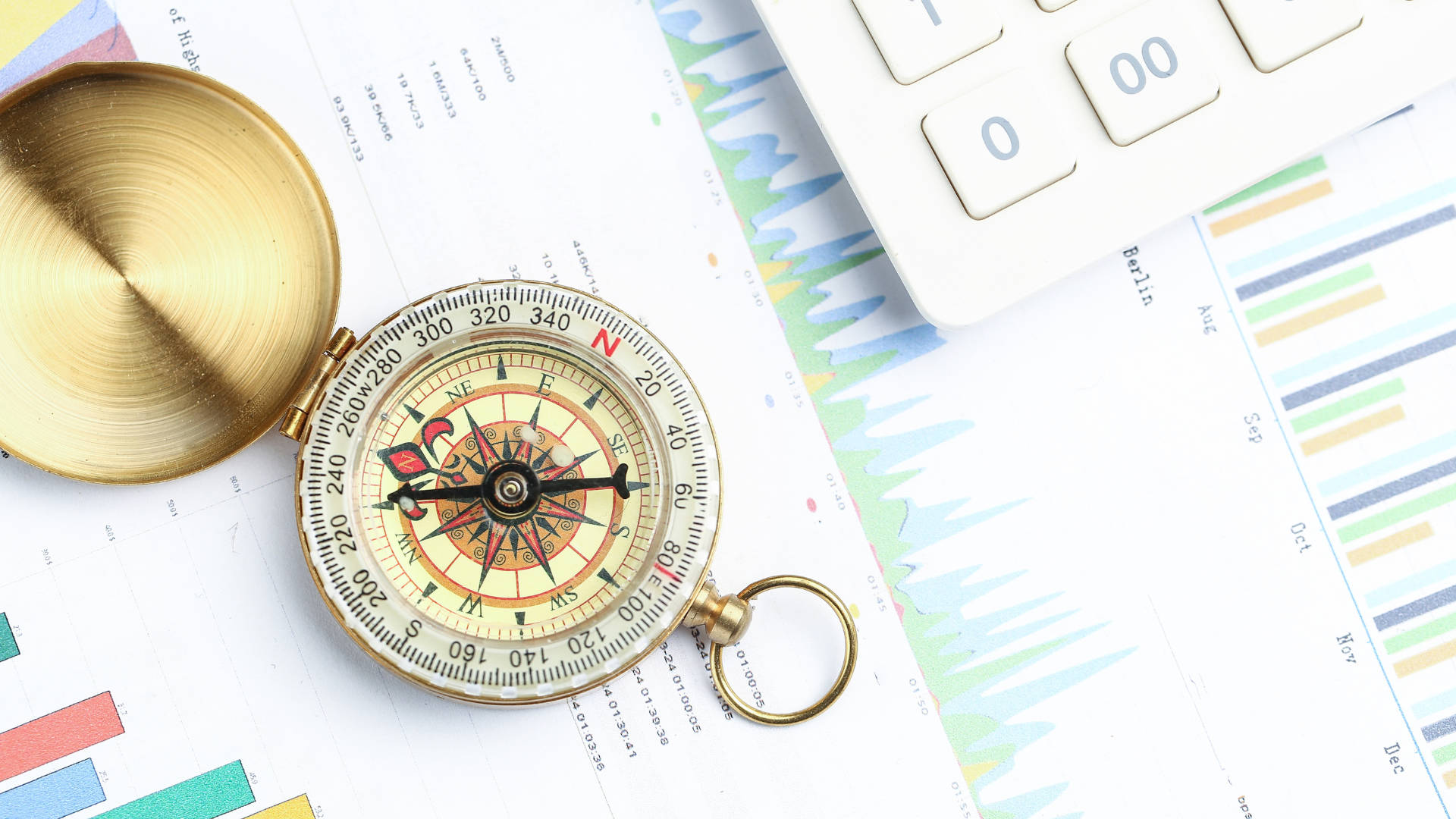 Compass is placed over statistics charts and near calculator