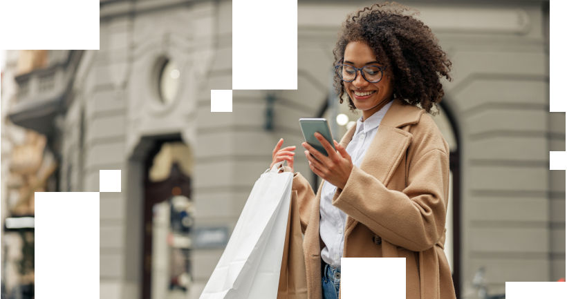 Fashion afro american woman after shopping with paper bags standing in city and using phone