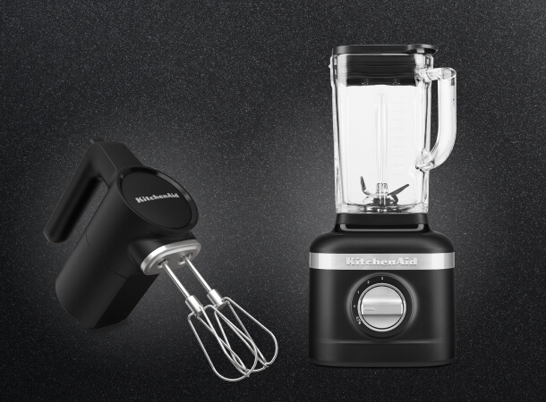Black KitchenAid® hand mixer and blender against a dark background.