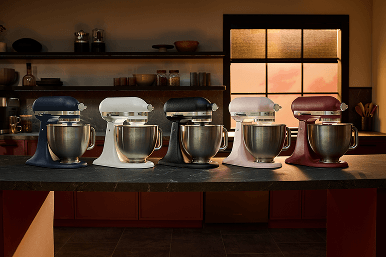 A series of five Artisan Plus stand mixers on a countertop.