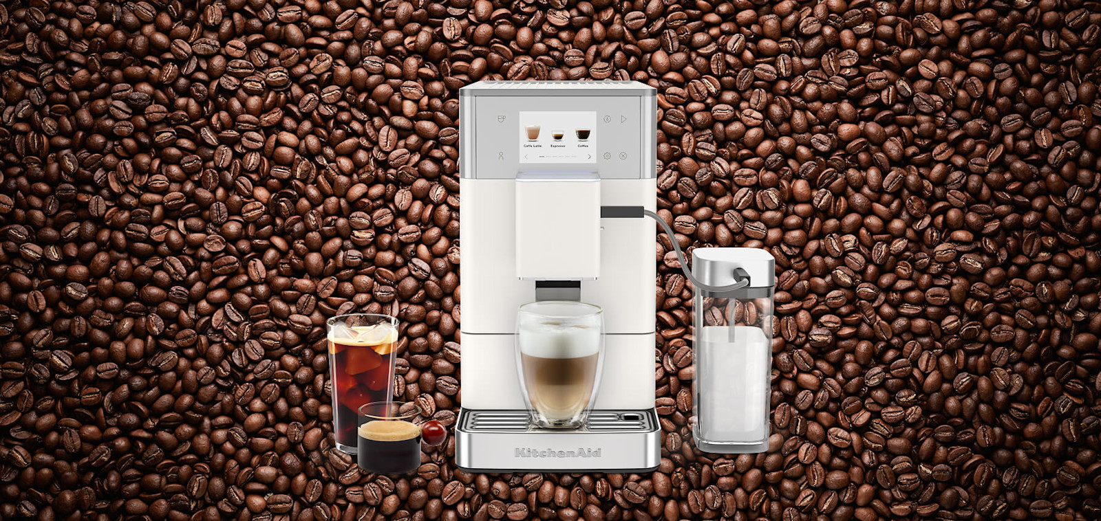 White KitchenAid® espresso machine dispensing a latte, set against a background of coffee beans