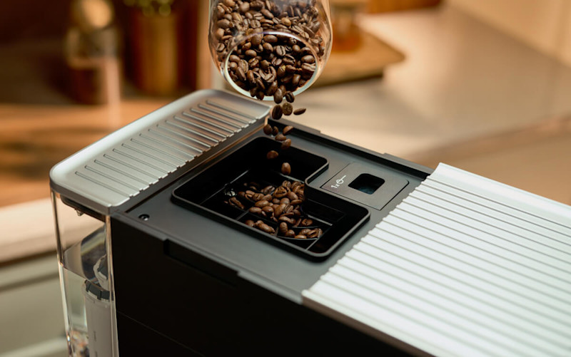 Beans getting poured into an espresso machine