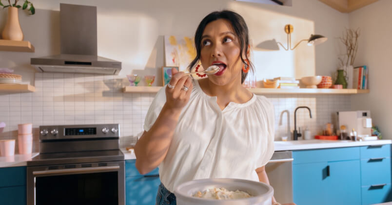 A woman tasting homemade ice cream with a spoon