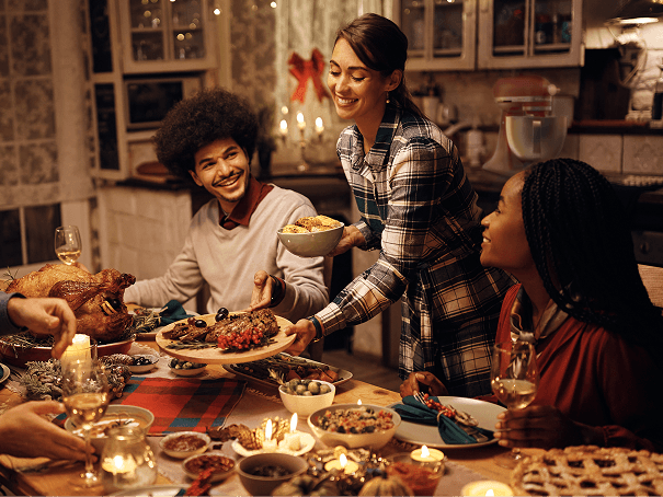 Group of friends gathered around a candlelit dinner table.