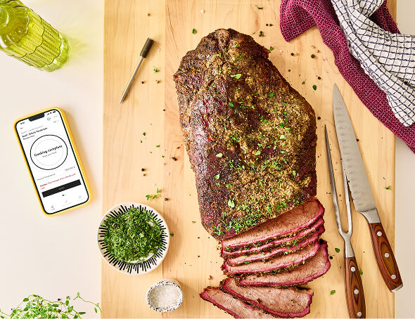 A KitchenAid® Smart Thermometer next to a plate of food
