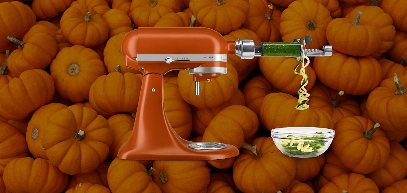 Orange KitchenAid® stand mixer bowl set against a background of pumpkins