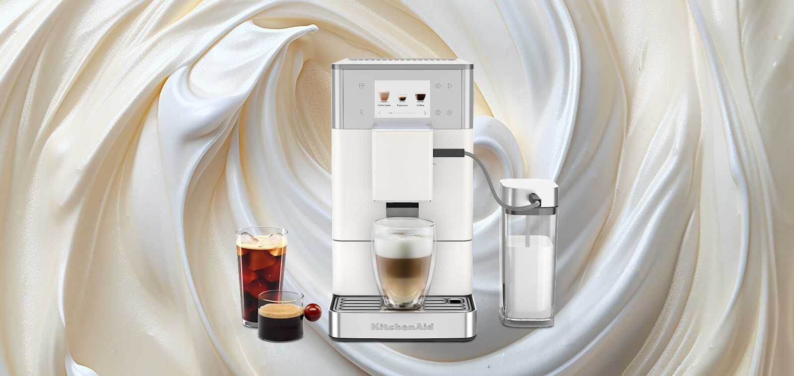 White KitchenAid® fully automatic espresso machine dispensing a latte, set against a swirling cream background