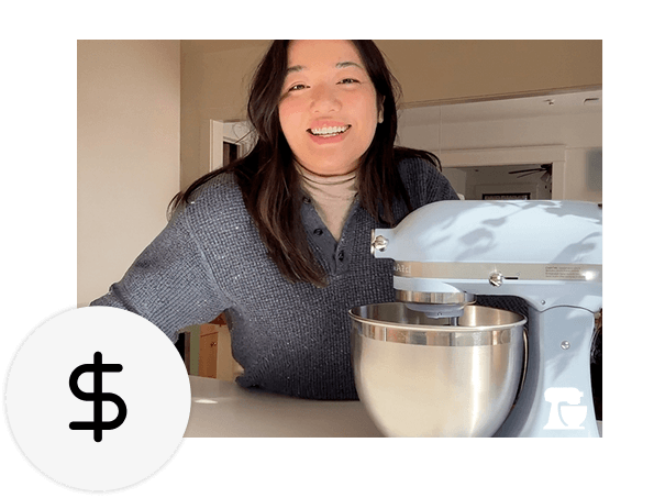 A person smiling next to a KitchenAid® stand mixer