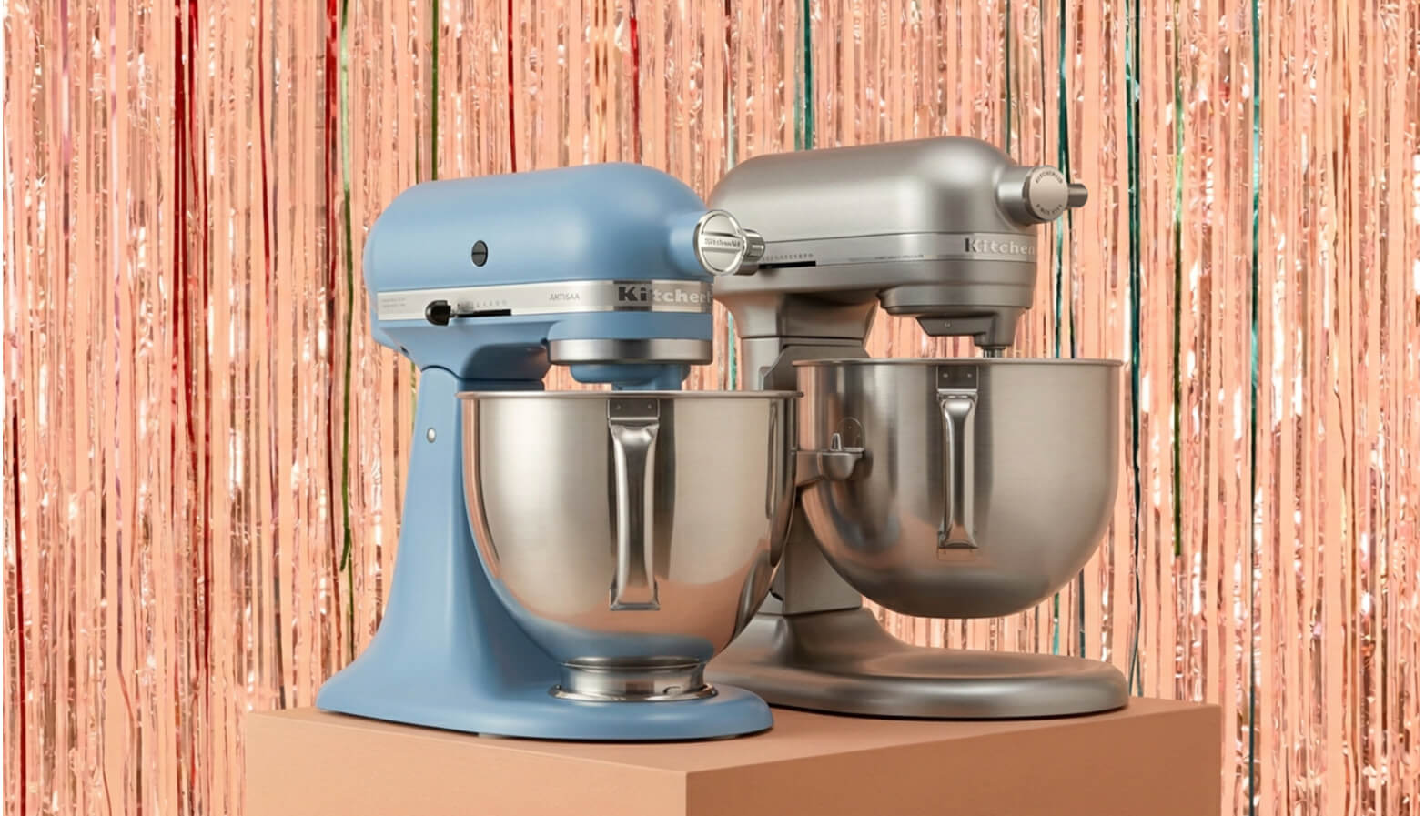 Two KitchenAid® stand mixers in front of a shiny decorative background