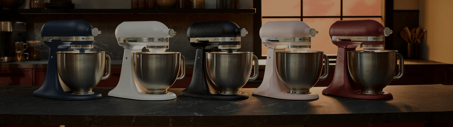 A series of five Artisan Plus stand mixers on a countertop.
