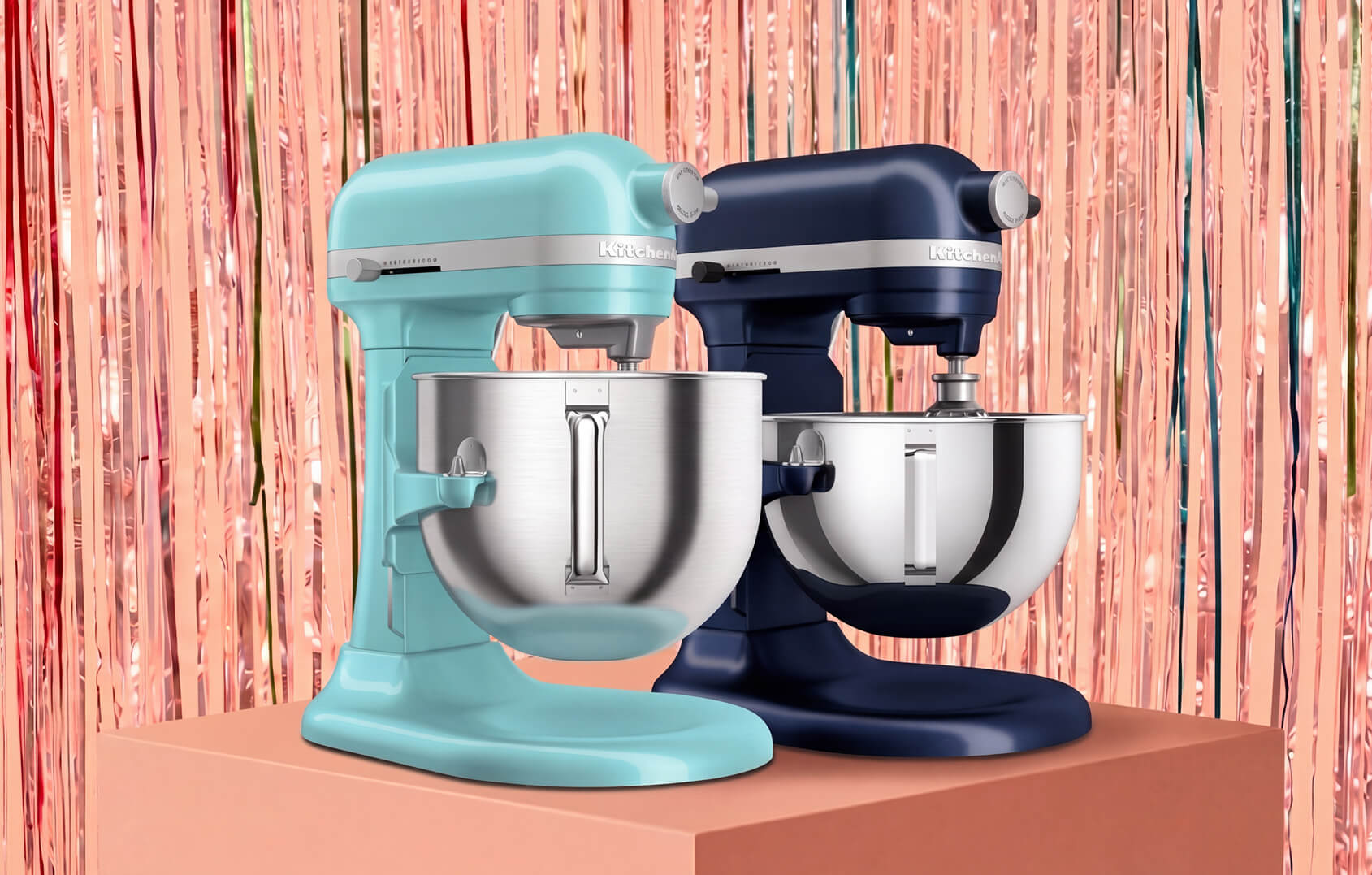 Two KitchenAid® stand mixers against a pink tinsel background.