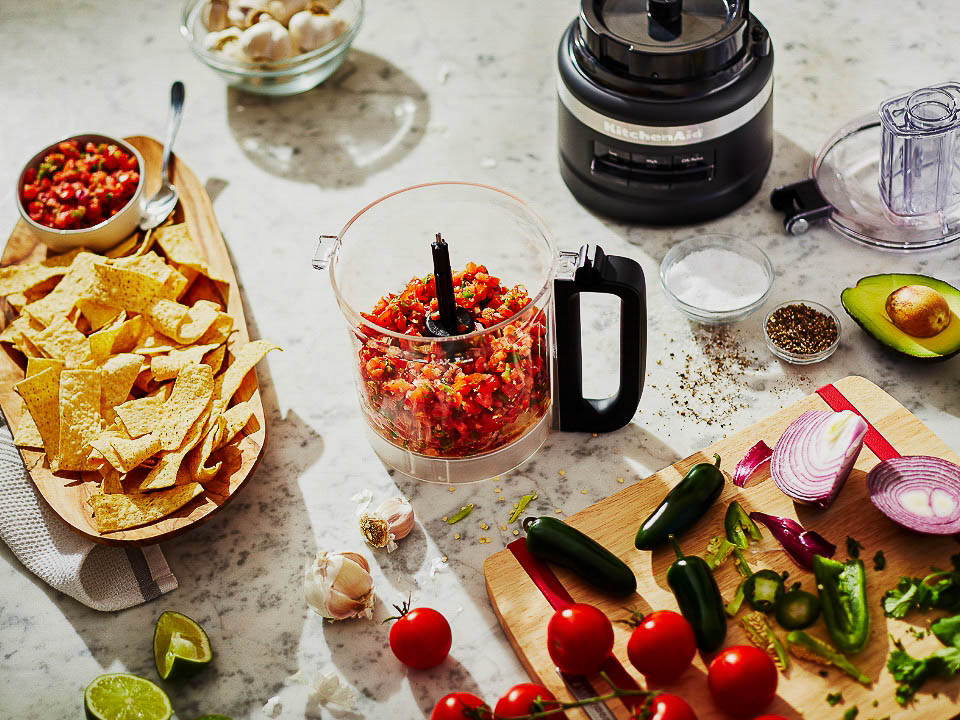 A food processor being used to make salsa.