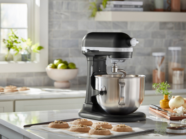 Black KitchenAid® stand mixer on a counter beside a tray of cookies