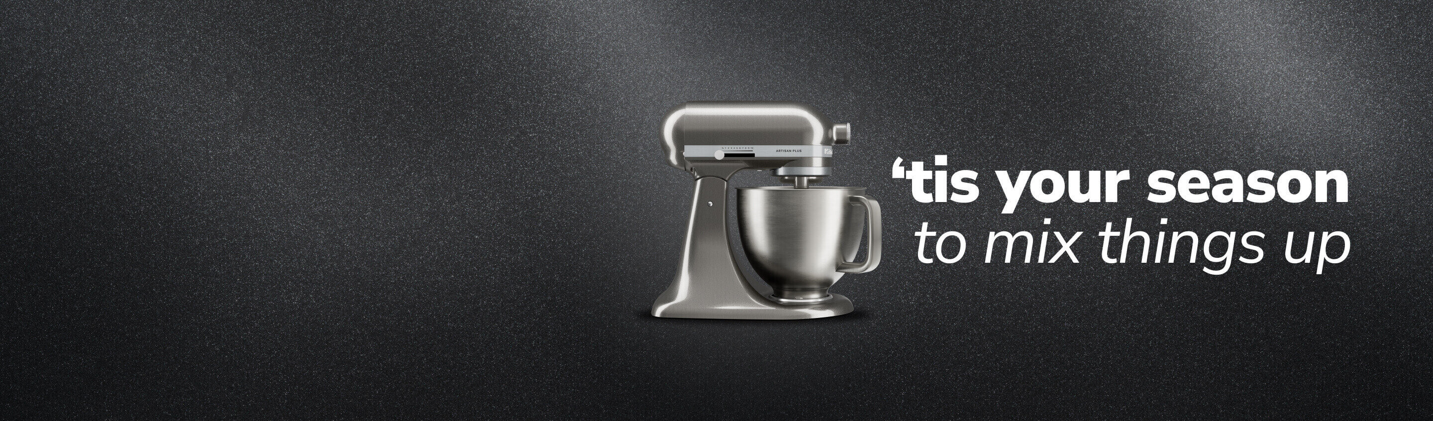 Side view of a silver KitchenAid® stand mixer against a dark background