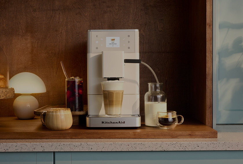 White KitchenAid<sup>®</sup> espresso machine dispensing a latte