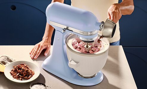 A person using a KitchenAid® stand mixer and ice cream attachment