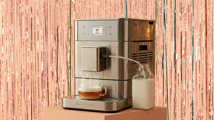 A KitchenAid® fully automatic espresso machine in front of a shiny decorative background