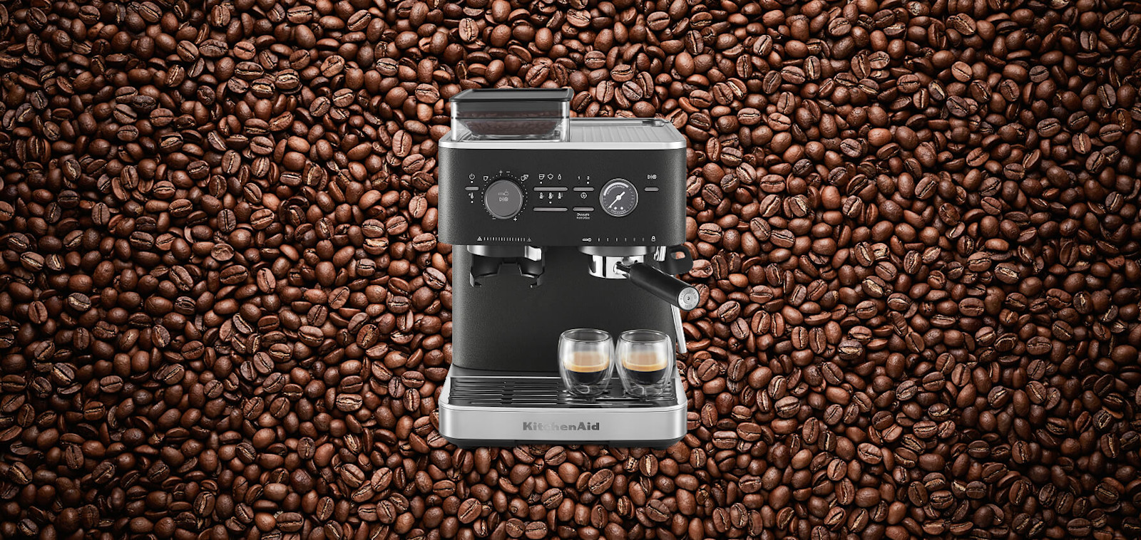 Black KitchenAid® semi automatic espresso machine, set against a background of coffee beans