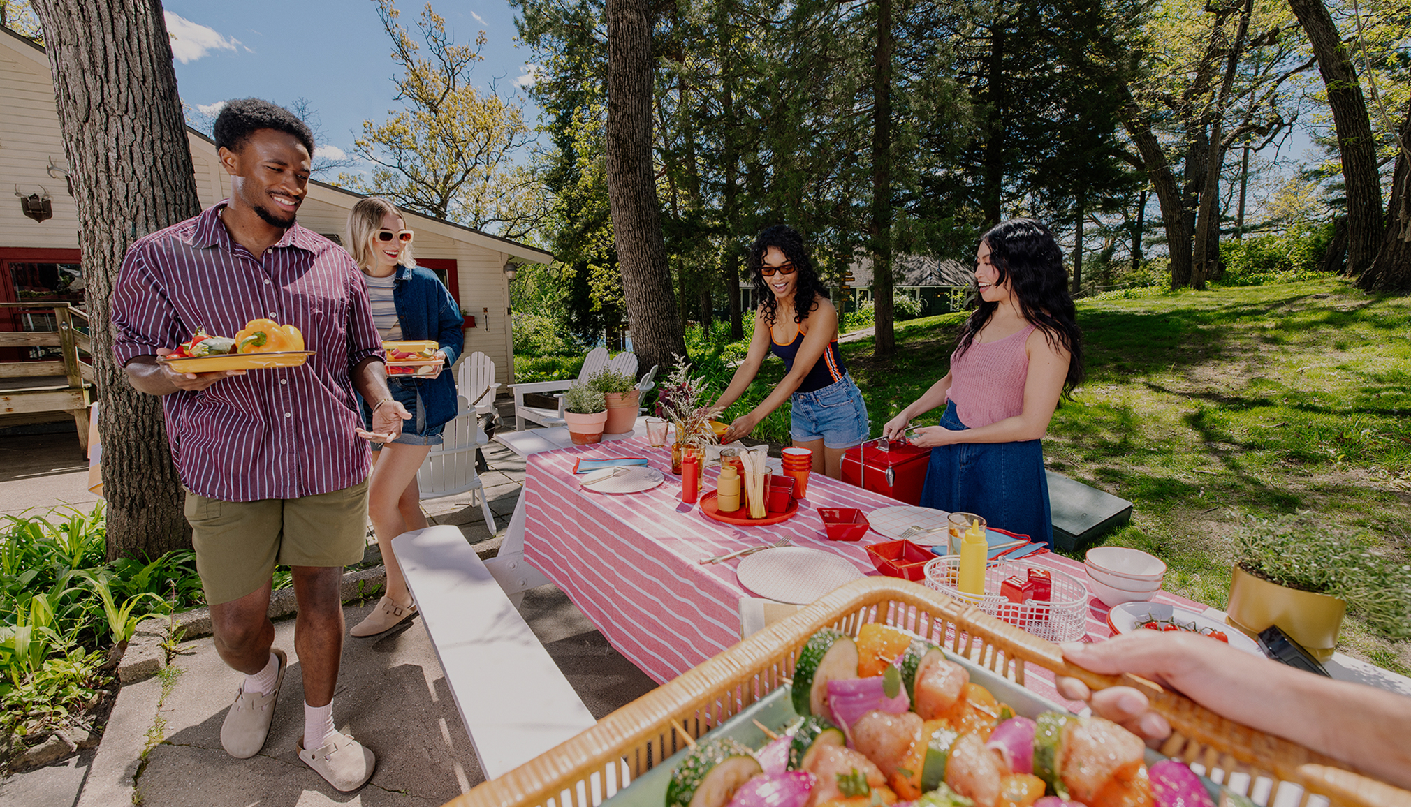 A fully-set picnic table at an outdoor summer gathering.