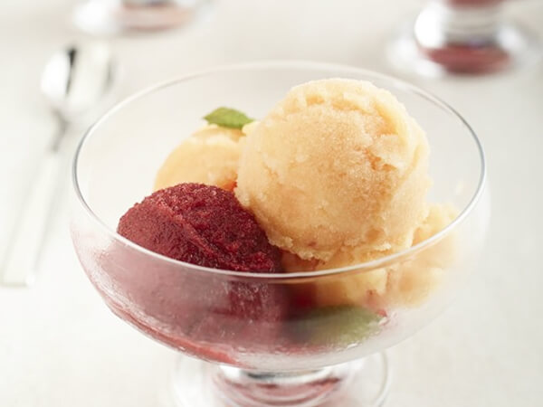 Scoops of fruit sorbet in a glass bowl