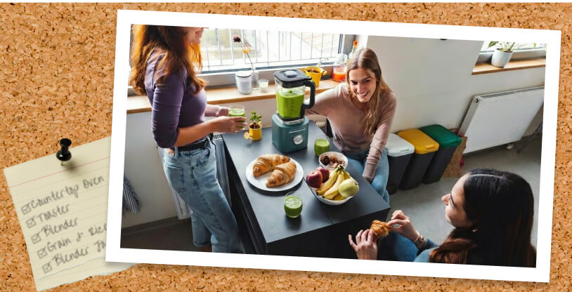 A corkboard with a picture of Friends sitting around a table with a KitchenAid® blender and breakfast food