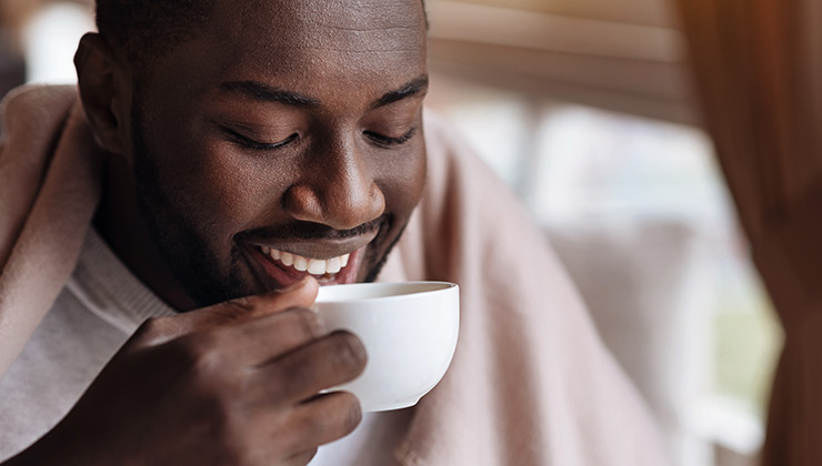 A man sips on a mug of tea.