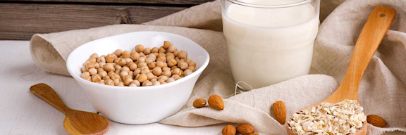 Bild von Hülsenfrüchten, Nüssen und Haferflocken auf einem beigen Tuch