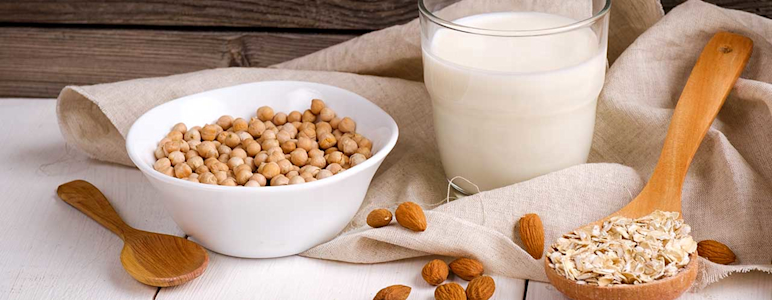 Bild von Hülsenfrüchten, Nüssen und Haferflocken auf einem beigen Tuch