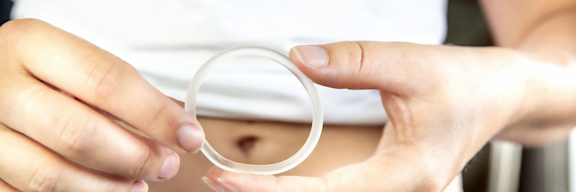 Eine Frau hält einen Verhütungsring (Vaginalring) in ihren Händen.