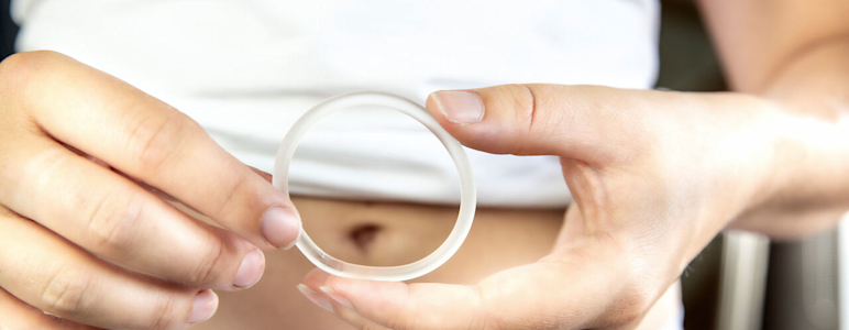 Eine Frau hält einen Verhütungsring (Vaginalring) in ihren Händen.