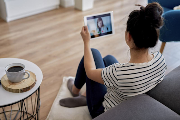 Junge Frau hat Sprechstunde online am Tablet mit Ärztin.