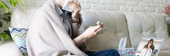 Mann hat Schnupfen und Fieber. Telemedizinische Videosprechstunde mit Ärztin.