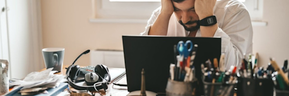 Mann mit Burnout ist verzweifelt im Büro oder Homeoffice.