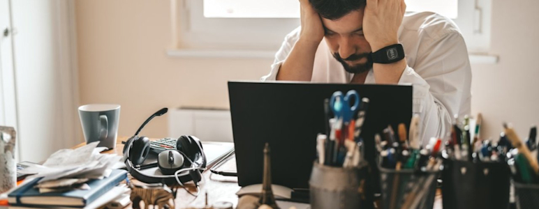 Mann mit Burnout ist verzweifelt im Büro oder Homeoffice.