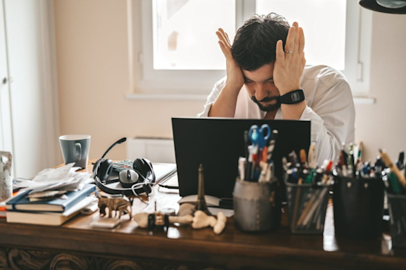 Mann mit Burnout ist verzweifelt im Büro oder Homeoffice.