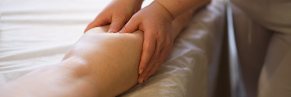 Eine Patientin erhält eine Lymphdrainage am Bein.