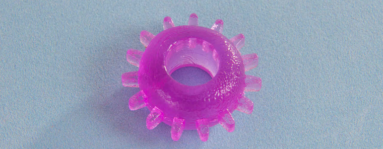 Ein Penisring aus durchsichtigem, lila Gummi.