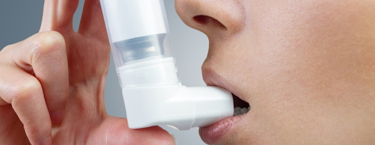 Frau verwendet Asthma-Spray mit Inhalator.
