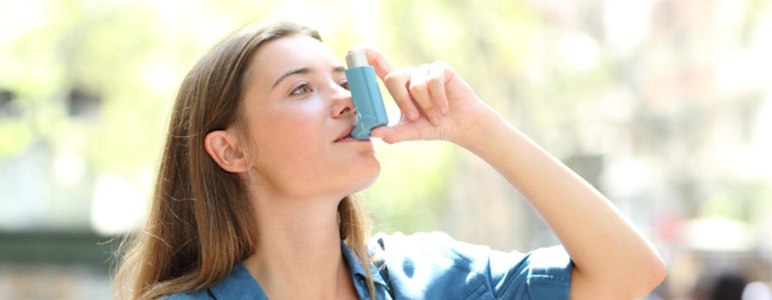 Eine Frau hält einen Asthma-Inhalator.