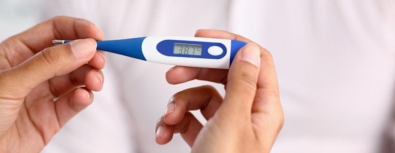 Ein Fieberthermometer zeigt 38,7 °C an.