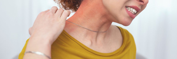 Junge Frau reagiert allergisch auf Kette. Schmuck mit Nickel kann Kontaktekzeme auslösen.